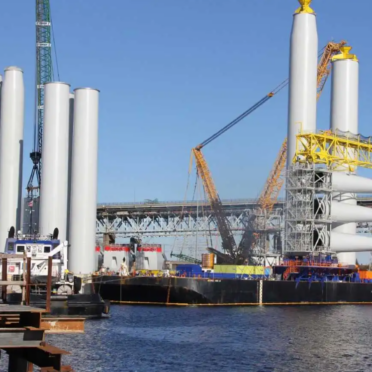 wind turbine construction materials sitting on ships in the ocean